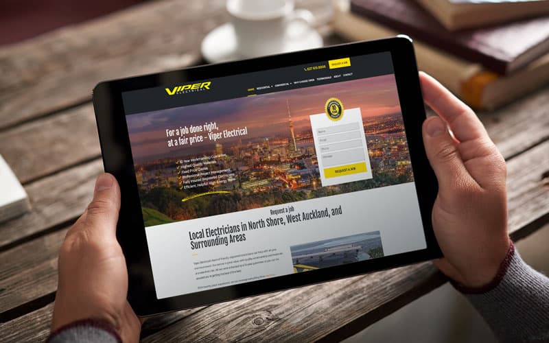 Small business web design shows a new website for an electrician displayed on a tablet with a bold black and yellow design