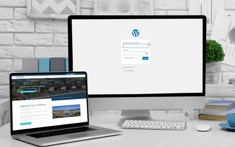 Wordpress web design login screen displayed on a computer with a laptop open beside it showing an attractive website design